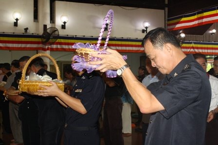 警员们为佛陀献上献花、果、素菜等。